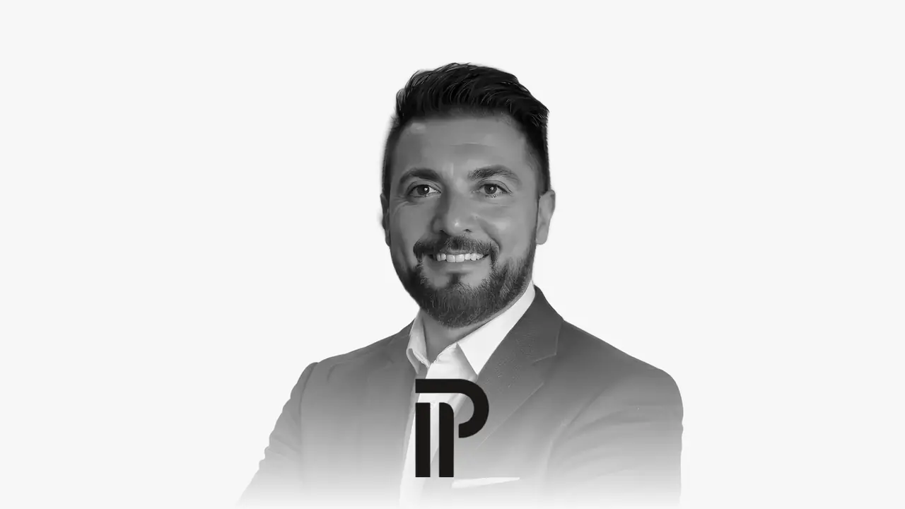 Portrait en noir et blanc de Saverio Pallocca avec le logo de Pallocca Immobilien