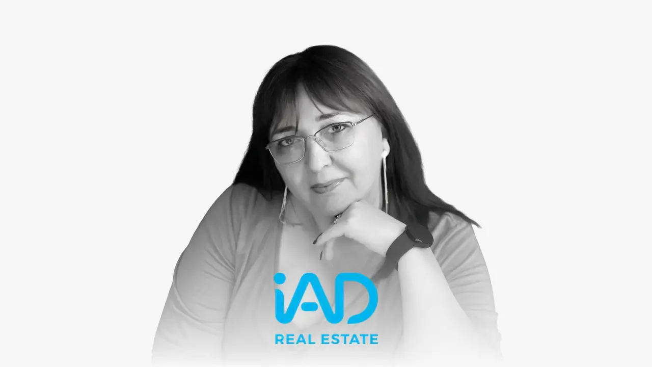 Black-and-white portrait of Marga Cano with the iAD logo