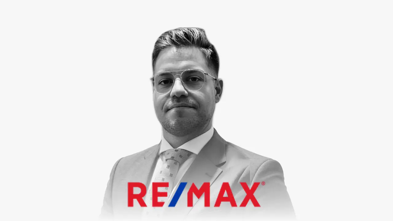 Ritratto in bianco e nero di Antonio Prieto con il logo di RE/MAX