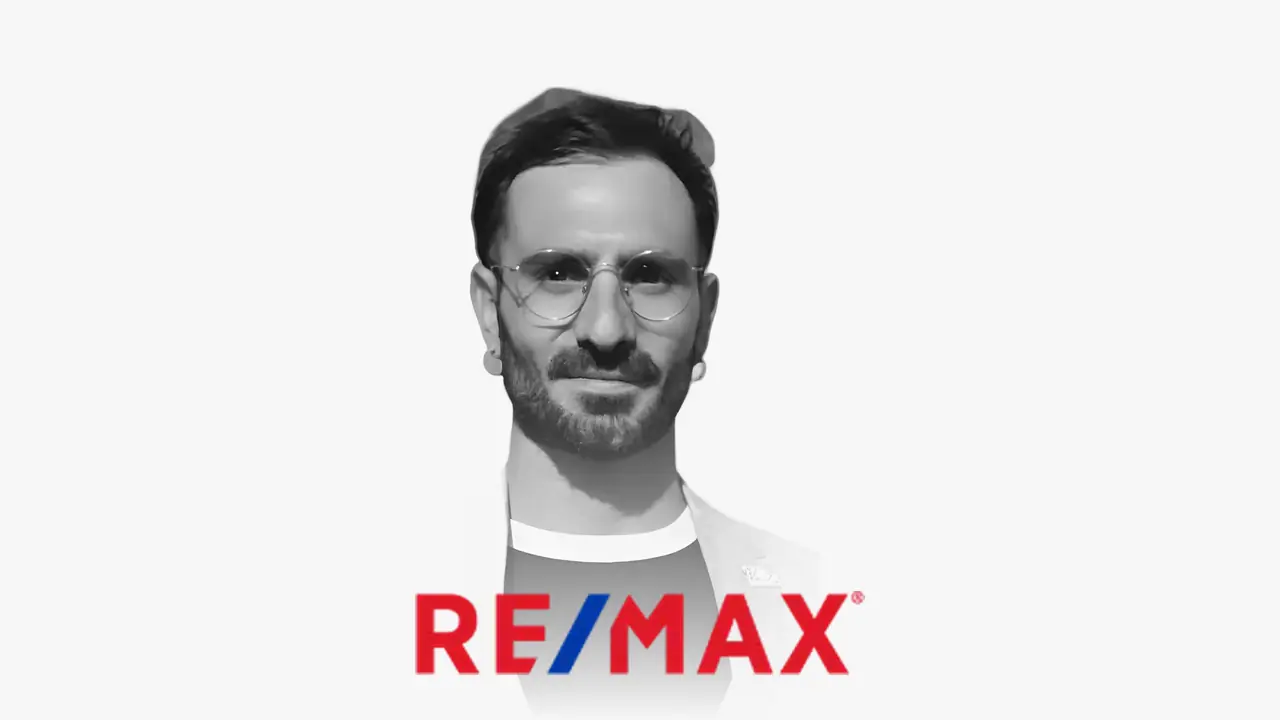 Ritratto in bianco e nero di Mariano Herrera con il logo di RE/MAX